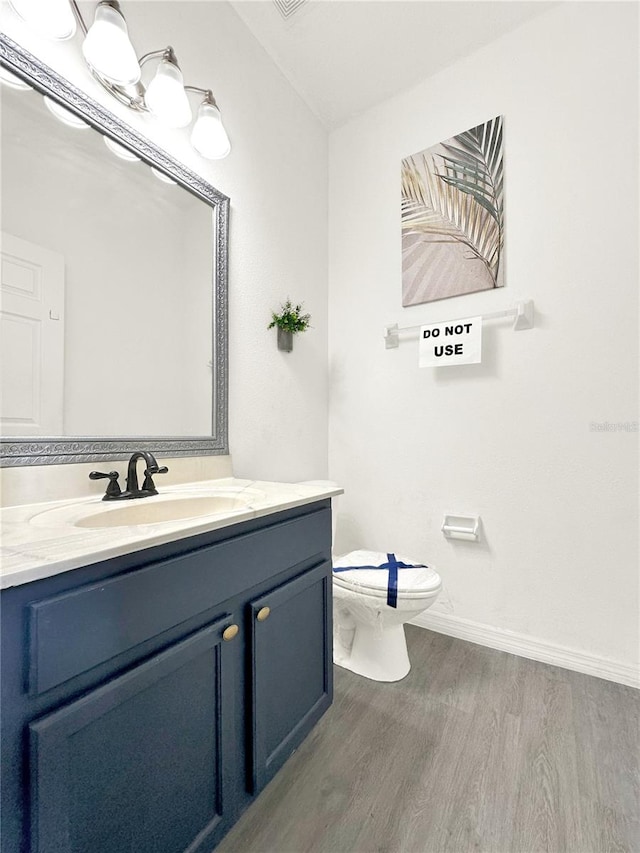 bathroom featuring hardwood / wood-style flooring, vanity, and toilet