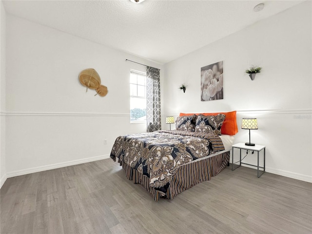 bedroom with hardwood / wood-style floors and a textured ceiling