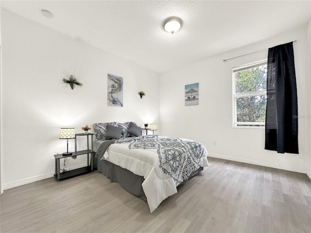 bedroom featuring wood-type flooring and a textured ceiling