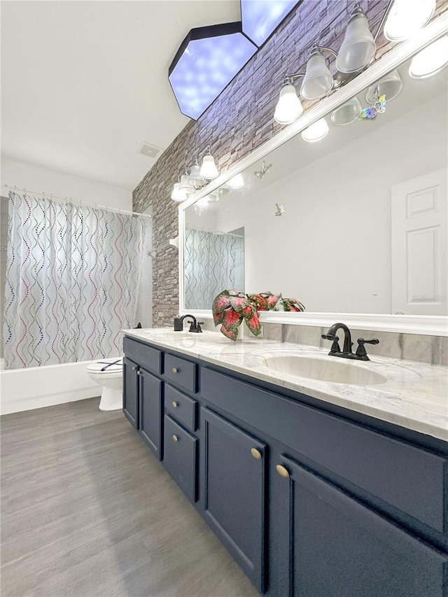 full bathroom with vanity, toilet, wood-type flooring, and shower / bath combo