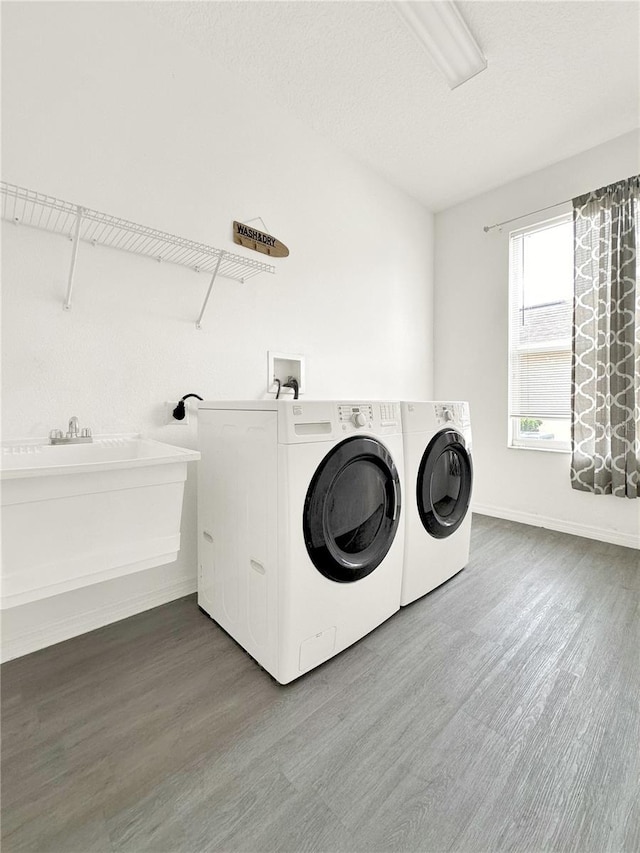 washroom featuring hardwood / wood-style floors, washer and dryer, and a textured ceiling