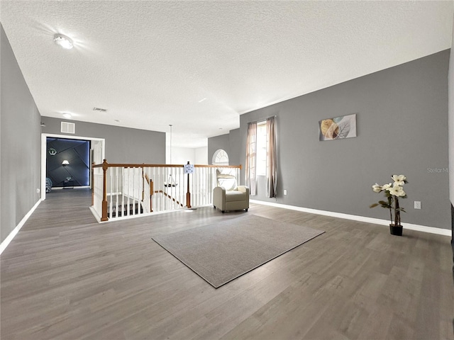 unfurnished room featuring hardwood / wood-style flooring and a textured ceiling