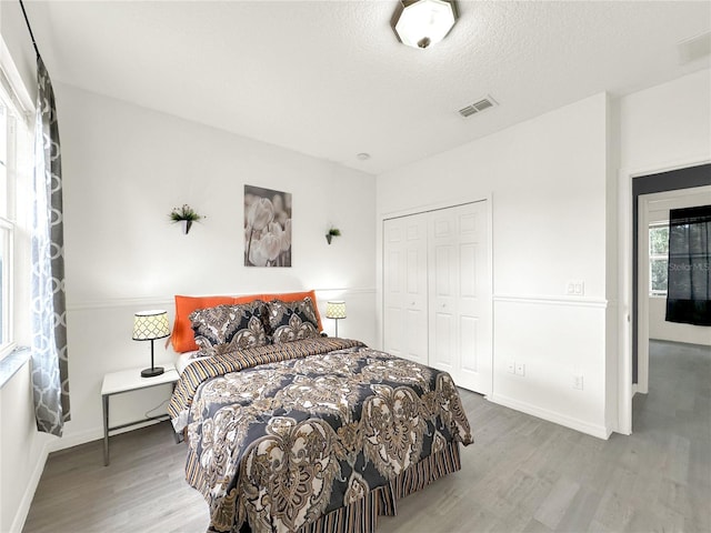 bedroom featuring hardwood / wood-style flooring, a closet, and a textured ceiling