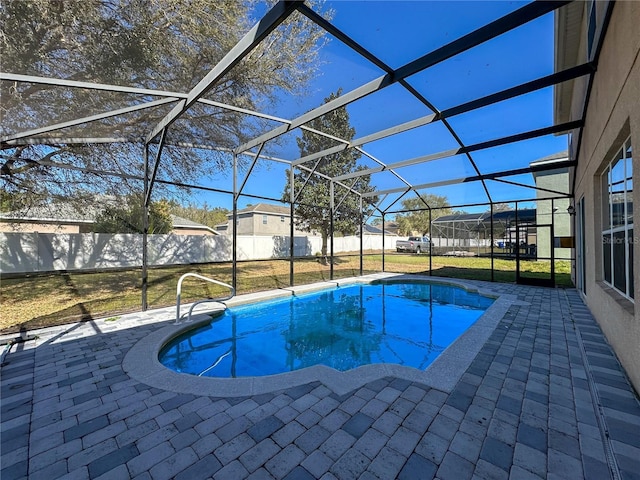 view of swimming pool with a yard, a patio area, and glass enclosure