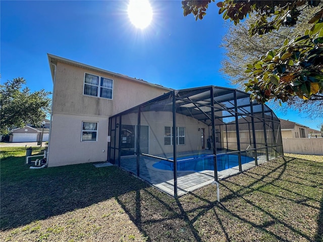 rear view of house with a fenced in pool, a patio area, glass enclosure, and a lawn