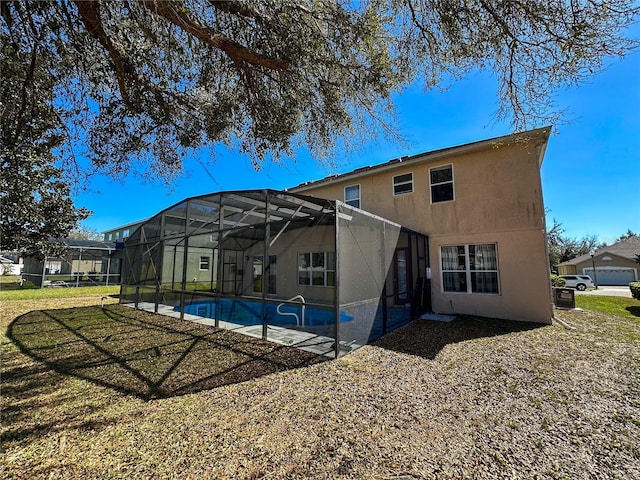 back of house featuring a lanai and a lawn