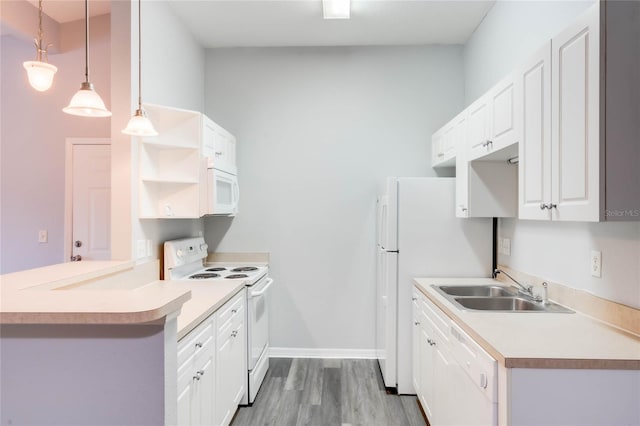 kitchen with kitchen peninsula, hanging light fixtures, white cabinetry, light hardwood / wood-style flooring, and white appliances