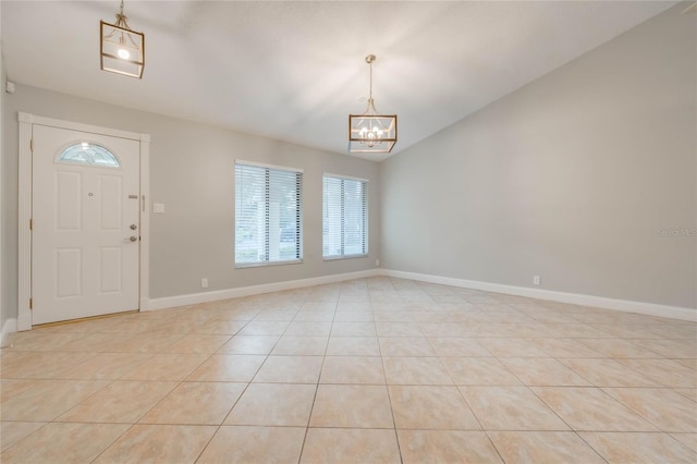 tiled entryway featuring a notable chandelier