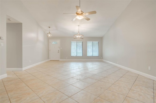 tiled spare room with ceiling fan with notable chandelier and vaulted ceiling