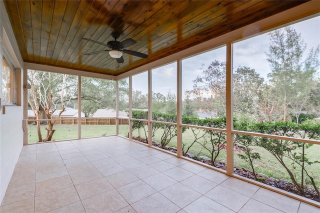 unfurnished sunroom with ceiling fan, wooden ceiling, and a healthy amount of sunlight