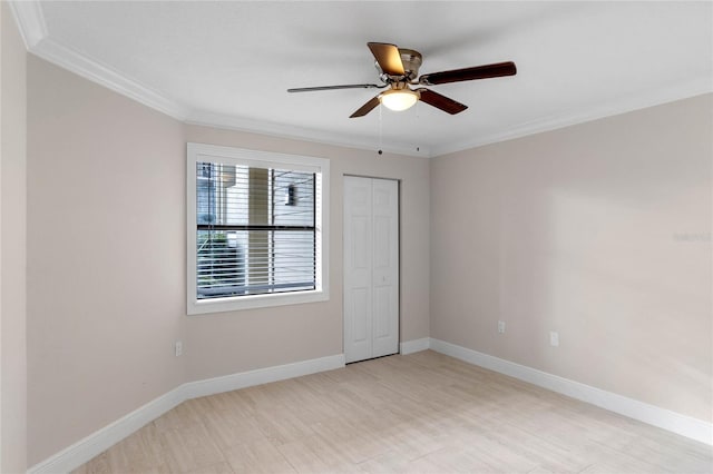 unfurnished bedroom with ceiling fan, a closet, and ornamental molding