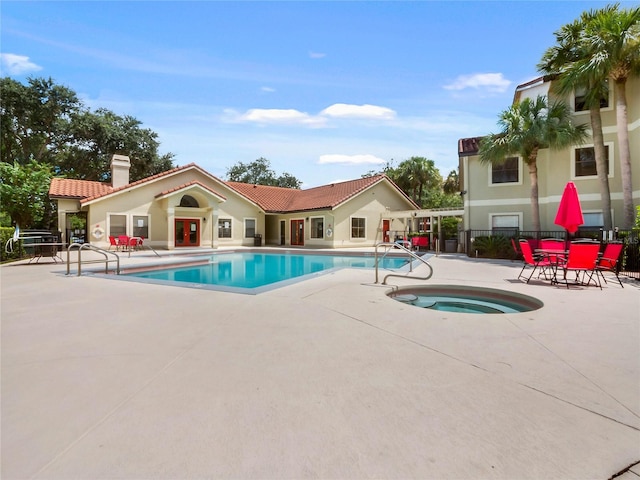 view of swimming pool featuring a community hot tub and a patio