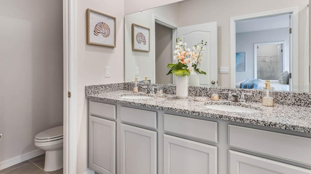 bathroom featuring vanity, tile patterned floors, and toilet