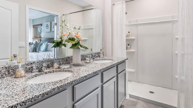 bathroom featuring tile patterned flooring, vanity, and curtained shower