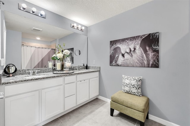 bathroom with walk in shower, tile patterned flooring, vanity, and a textured ceiling