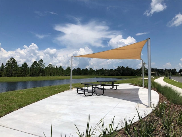 view of home's community featuring a water view and a lawn