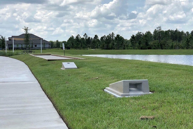 surrounding community featuring a water view and a yard