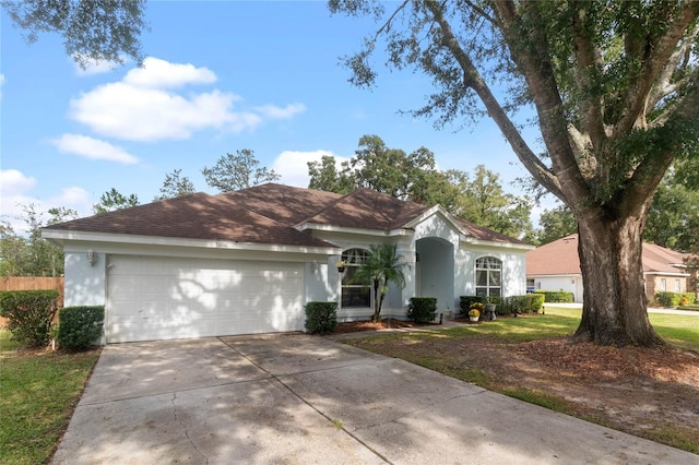 ranch-style home with a garage and a front lawn