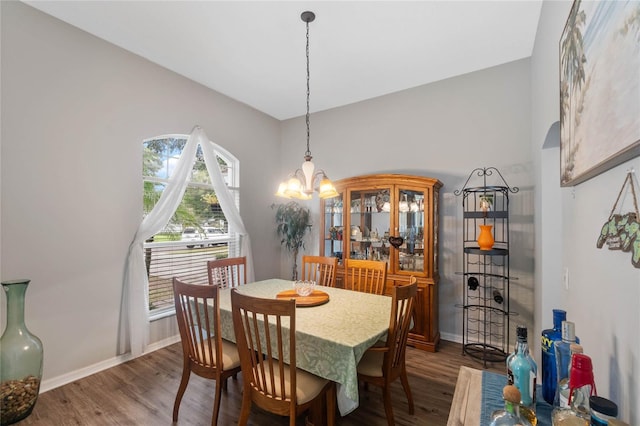 dining space with dark hardwood / wood-style flooring and a notable chandelier