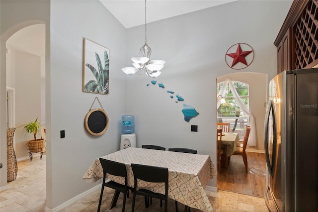 dining room featuring vaulted ceiling and a chandelier