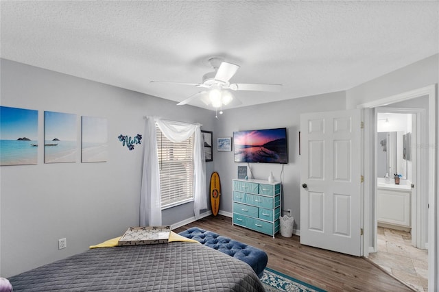 bedroom featuring ceiling fan, hardwood / wood-style floors, and a textured ceiling