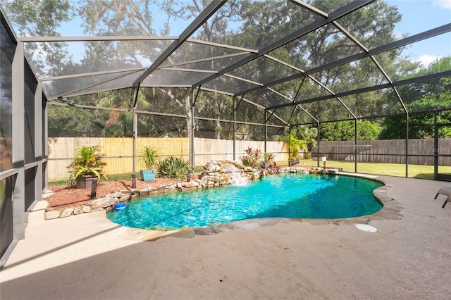 view of pool with pool water feature, glass enclosure, and a patio area