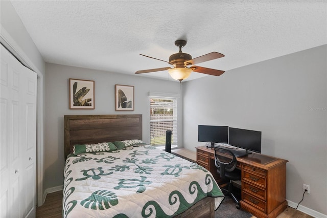 bedroom with ceiling fan, dark hardwood / wood-style floors, a closet, and a textured ceiling