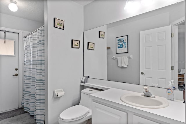 bathroom with vanity, a textured ceiling, and toilet