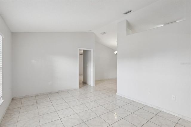 tiled empty room featuring vaulted ceiling