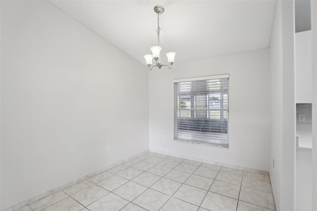 spare room featuring a notable chandelier and light tile patterned floors