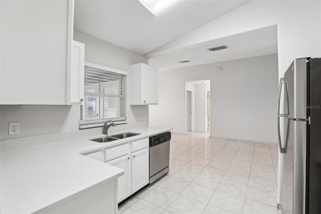 kitchen featuring lofted ceiling, white cabinets, sink, light tile patterned floors, and stainless steel appliances