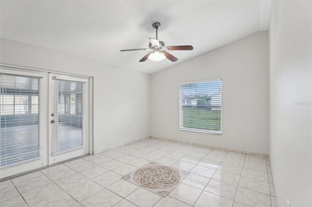 tiled empty room with a textured ceiling, a wealth of natural light, ceiling fan, and lofted ceiling