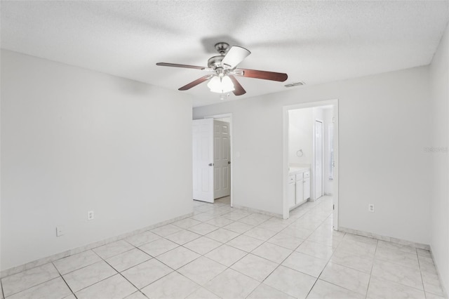 tiled spare room with ceiling fan and a textured ceiling