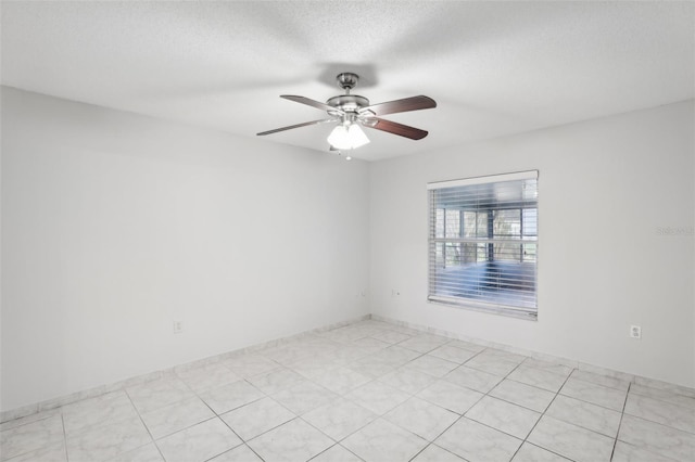 unfurnished room with ceiling fan and a textured ceiling