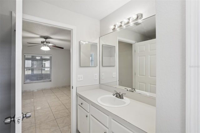 bathroom featuring ceiling fan, tile patterned flooring, vanity, and a textured ceiling