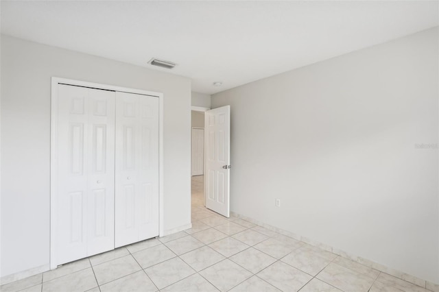 unfurnished bedroom with light tile patterned flooring and a closet