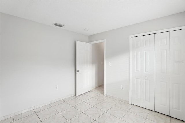 unfurnished bedroom featuring light tile patterned floors and a closet