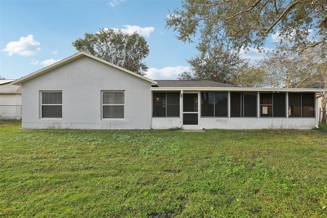 back of property featuring a sunroom and a yard