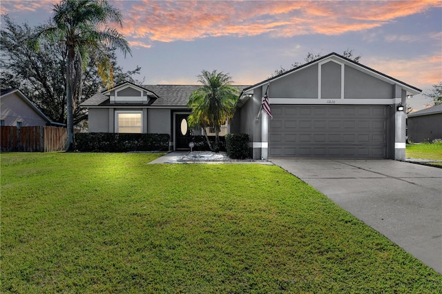 ranch-style house with a garage and a yard