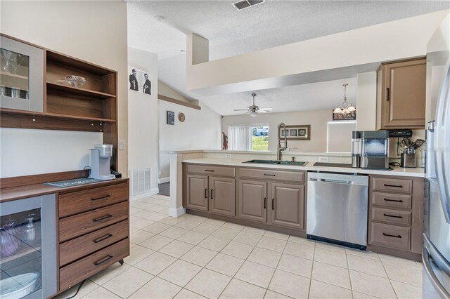 kitchen with ceiling fan with notable chandelier, stainless steel appliances, lofted ceiling, hanging light fixtures, and sink