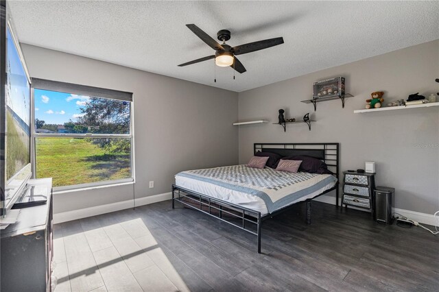 bedroom featuring hardwood / wood-style flooring, ceiling fan, and a textured ceiling