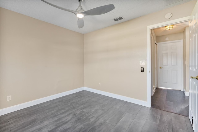 spare room with a textured ceiling, dark hardwood / wood-style flooring, and ceiling fan