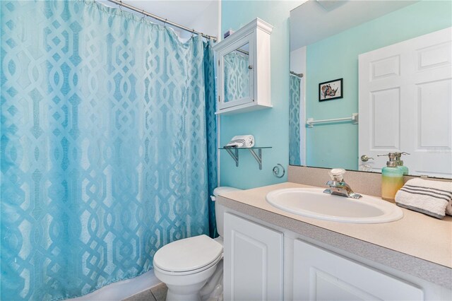 bathroom with toilet, a shower with curtain, vanity, and tile patterned flooring