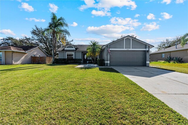 ranch-style house featuring a garage and a front lawn