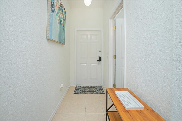 121 Palermo St, Davenport, FL 33897 - doorway to outside featuring a textured wall, tile patterned flooring, and baseboards