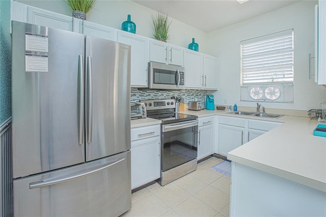 kitchen featuring decorative backsplash, appliances with stainless steel finishes, sink, white cabinets, and light tile patterned flooring