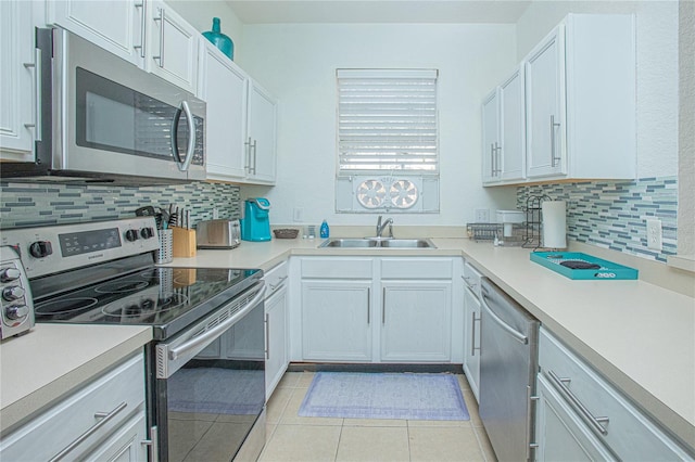 kitchen featuring light tile patterned floors, stainless steel appliances, white cabinetry, and sink