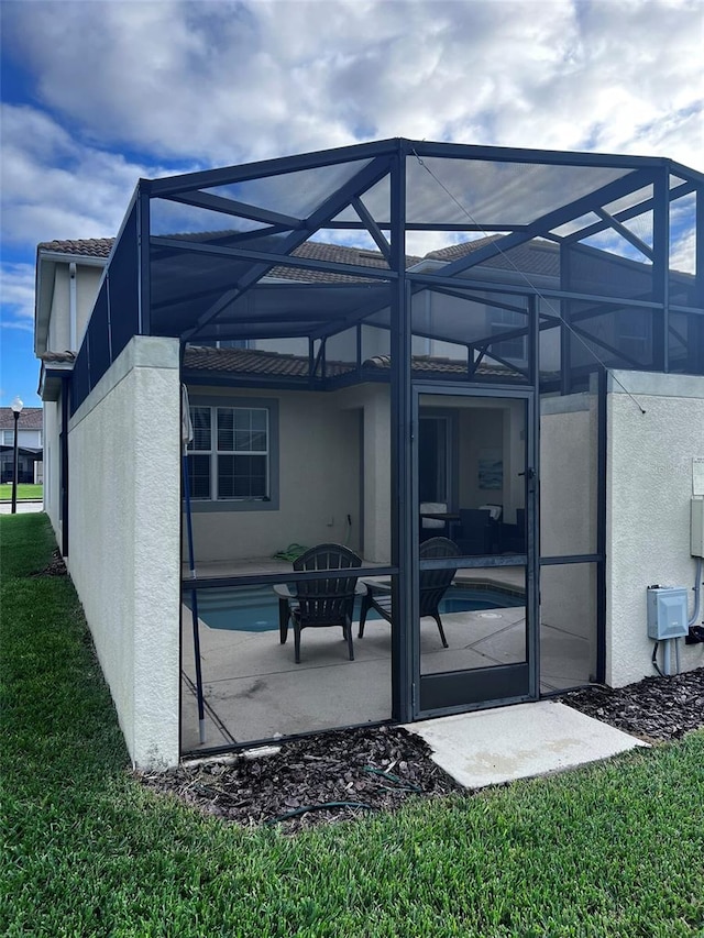 rear view of house with a lanai and a patio