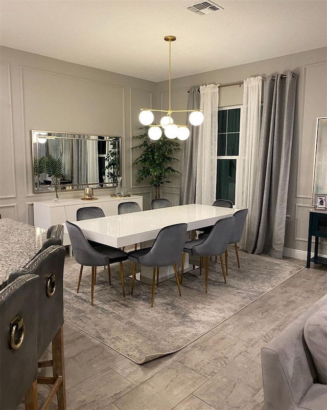 dining room featuring hardwood / wood-style flooring and an inviting chandelier