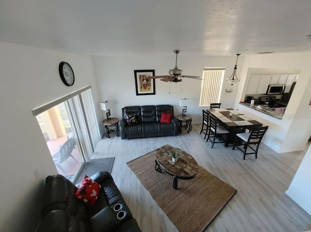 living room with light hardwood / wood-style flooring and ceiling fan